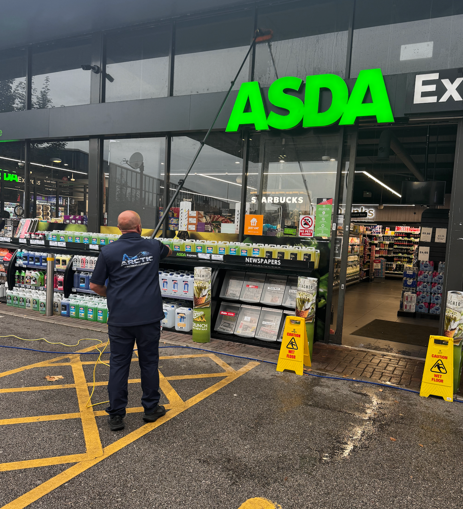 Arctic Exterior Cleaning technician water-fed pole cleaning the shopfront glazing at an ASDA Express store